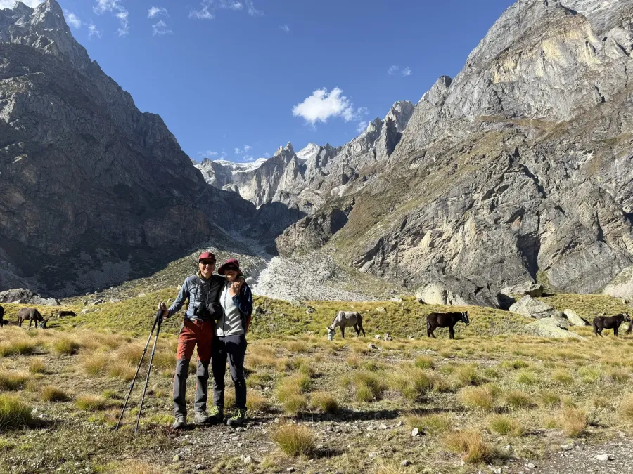 Martin and Lenka on a trek in the Himalaya, with mules grazing behind them