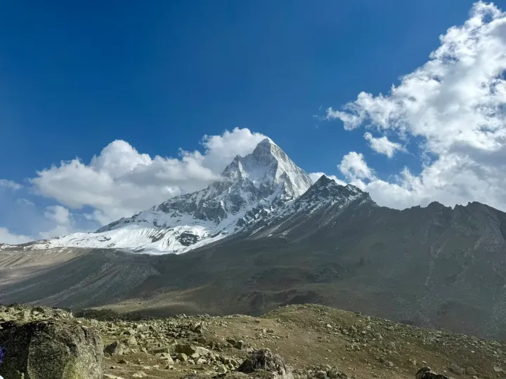 Mount Shivling rising above the Tapovan meadow under a blue sky with clouds