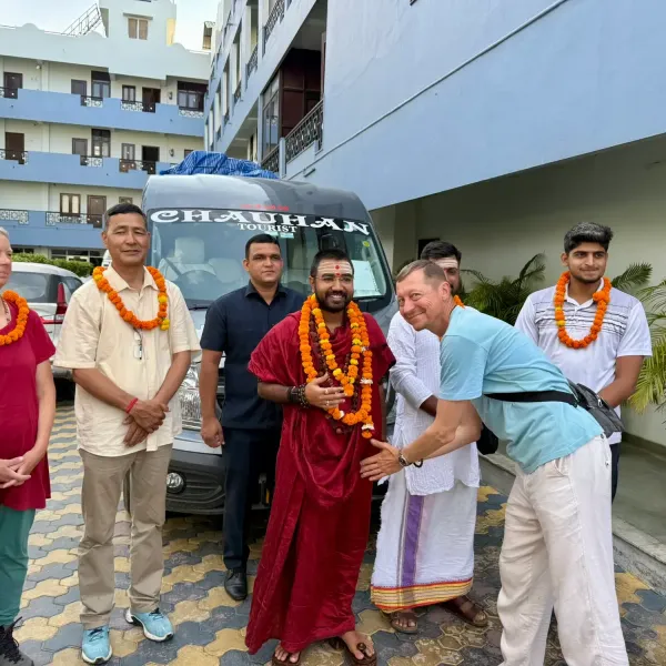 Group welcomed with marigold garlands beside the tour bus in Rishikesh