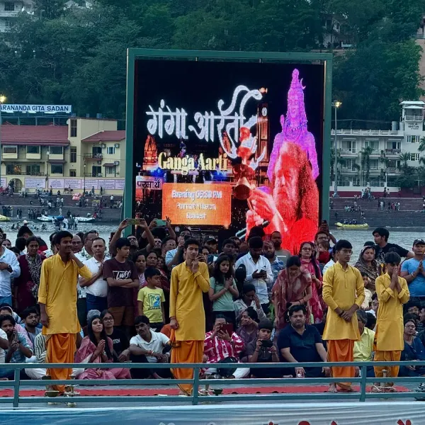 Young priests in yellow robes at the Ganga Aarti in Rishikesh in front of the crowd