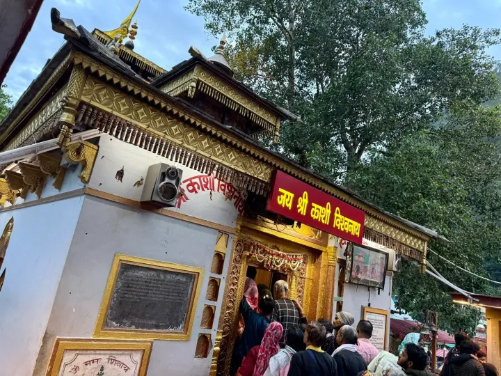 Wooden and gilded facade of the Kashi Vishwanath Temple in Uttarkashi with pilgrims at the entrance