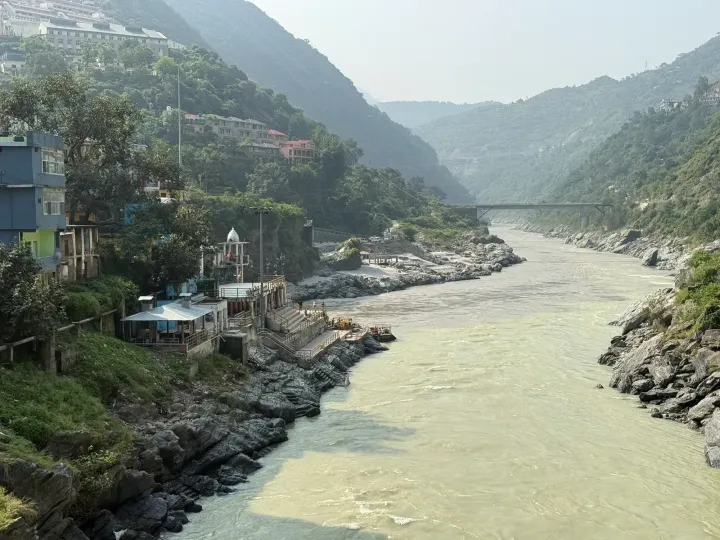 The Alaknanda valley at Devprayag with the small temple and ghats on the rocky bank and forested hills on both sides
