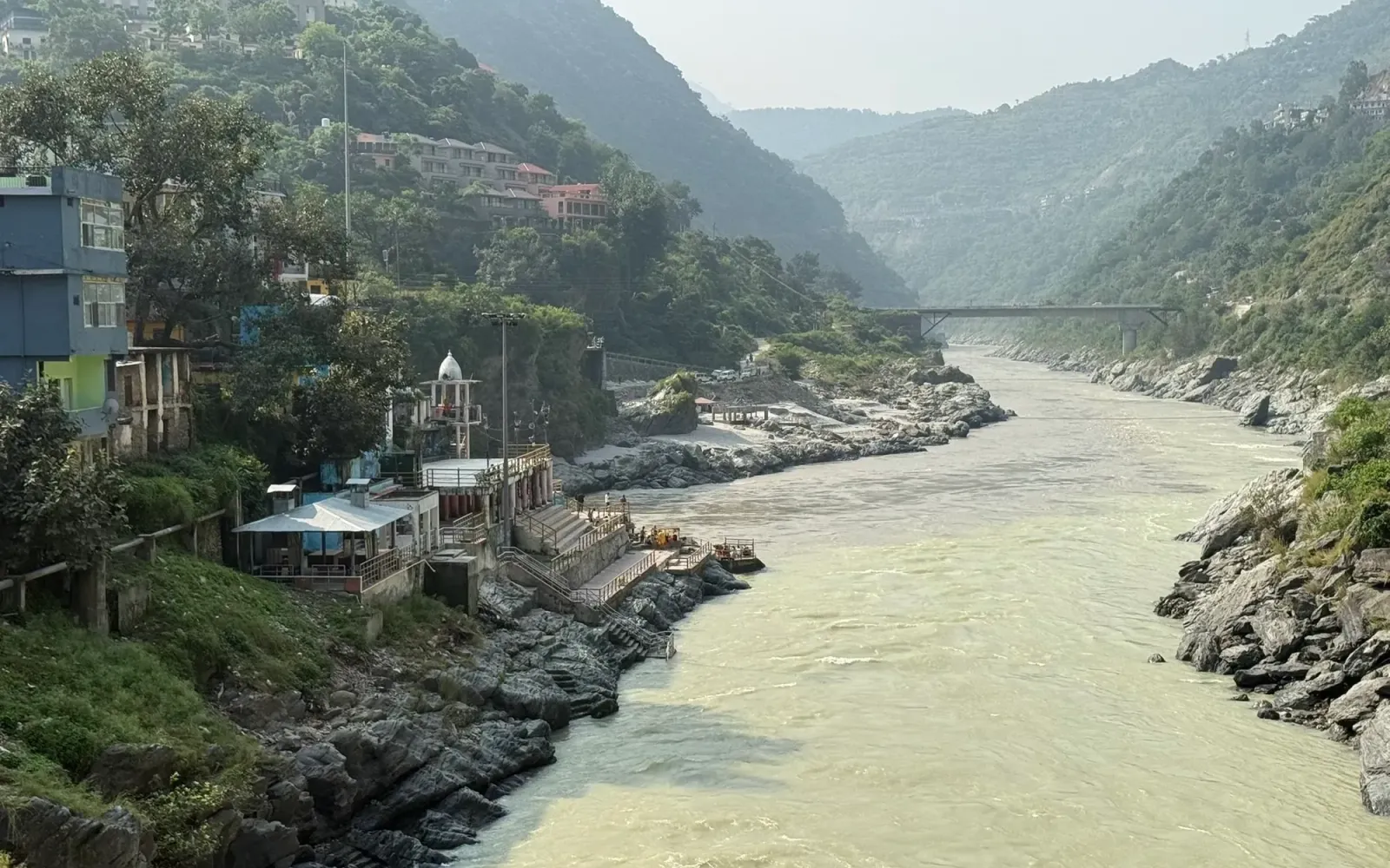 The Alaknanda valley at Devprayag with the small temple and ghats on the rocky bank and forested hills on both sides