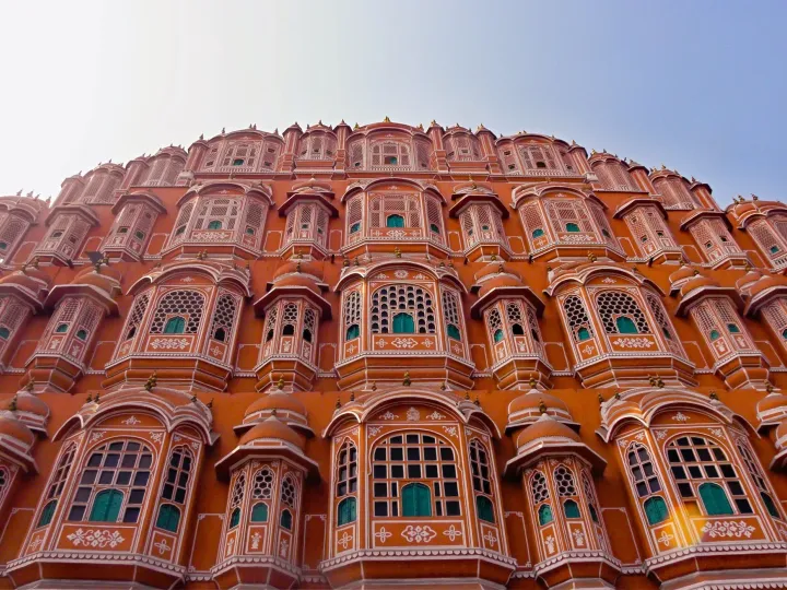 The pink honeycomb facade of Hawa Mahal in Jaipur against a pale sky
