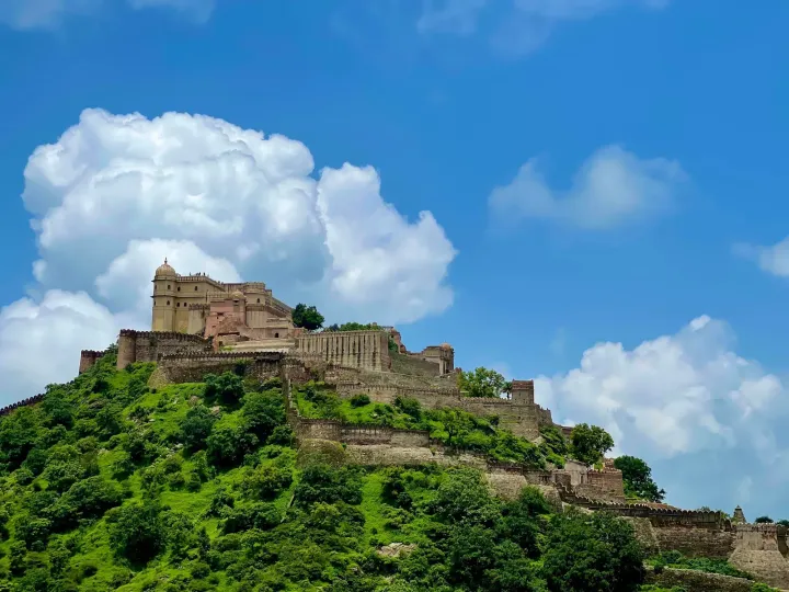 Kumbhalgarh Fort and its long walls on a green hilltop under a blue sky