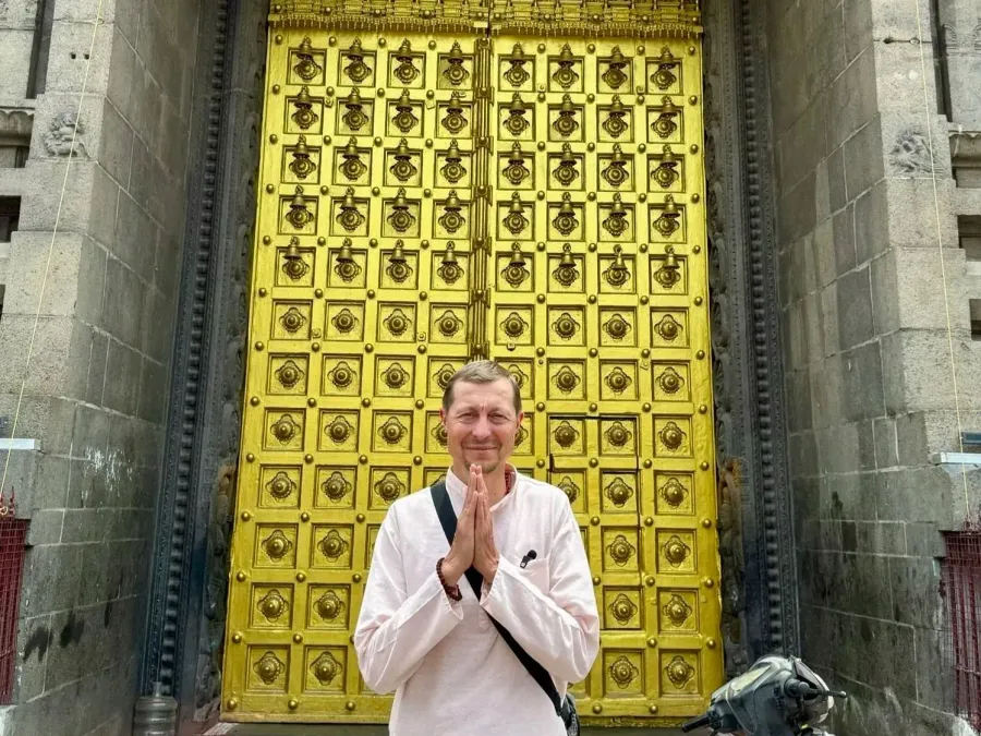 Martin Tetera greeting with folded hands in front of a golden temple door