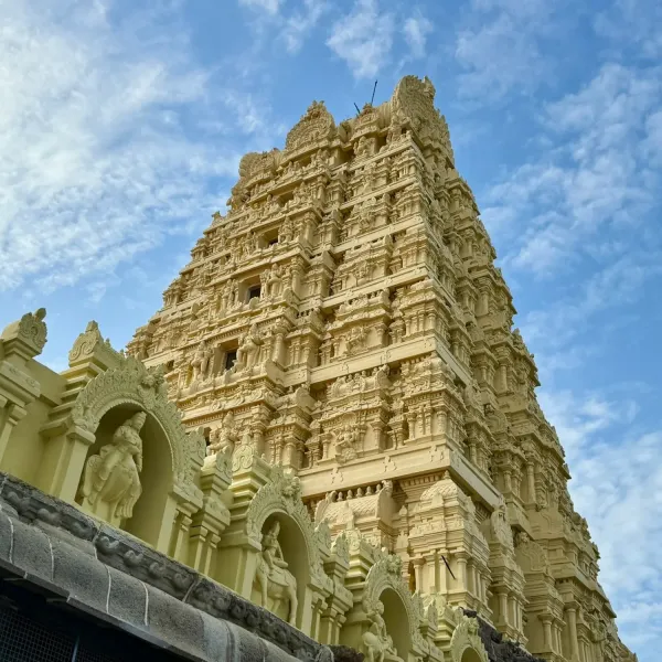 Ornately carved cream-coloured temple gopuram against a blue sky, Tamil Nadu