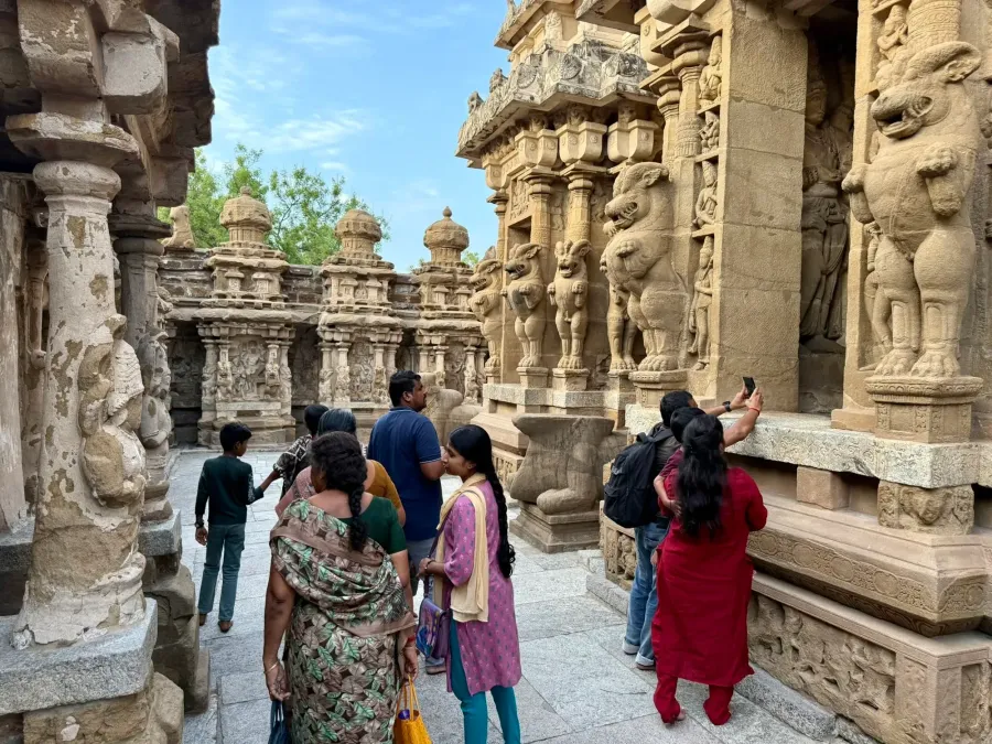 Visitors admiring the lion pillars and carved shrines of the Kailasanathar Temple in Kanchipuram
