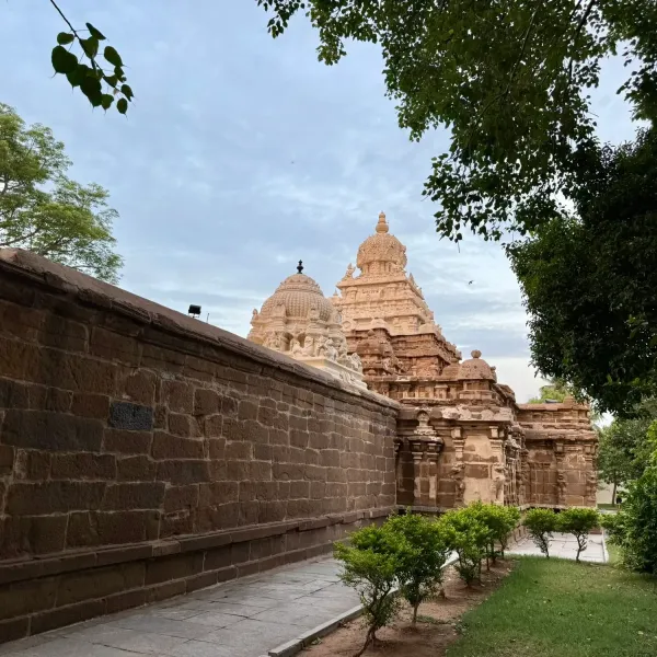 Sandstone towers of a Pallava-era temple rising behind a stone wall in Kanchipuram