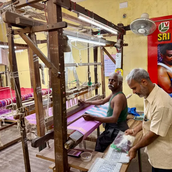 A weaver working at a wooden handloom in a silk workshop in Kanchipuram